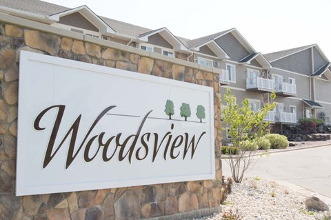 A sign that says Woodsview in front of a building.