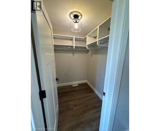 A small bedroom with a bunk bed and a light on.