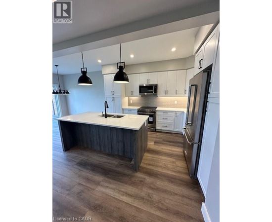 A modern kitchen with a large island and stainless steel appliances.