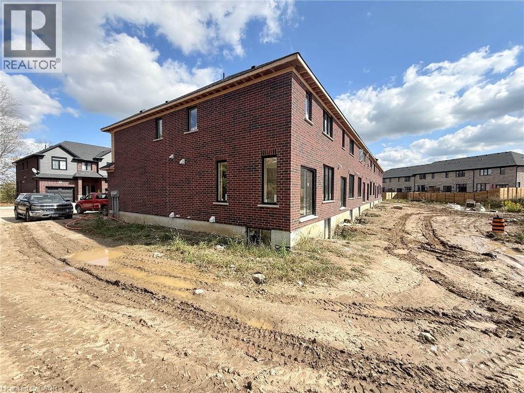 A red brick building with a white sign that says REALTOR in the upper left corner.
