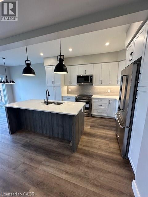 A modern kitchen with a large island and stainless steel appliances.