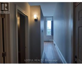 A hallway with a door on the left and a window on the right.