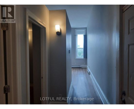 A hallway with a door on the left and a window on the right.