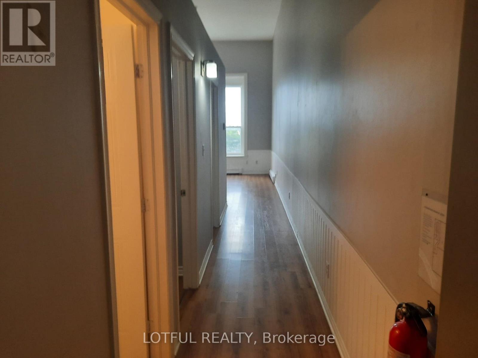 A hallway with a fire extinguisher on the right side.