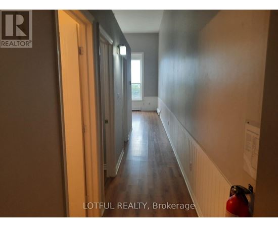 A hallway with a fire extinguisher on the right side.