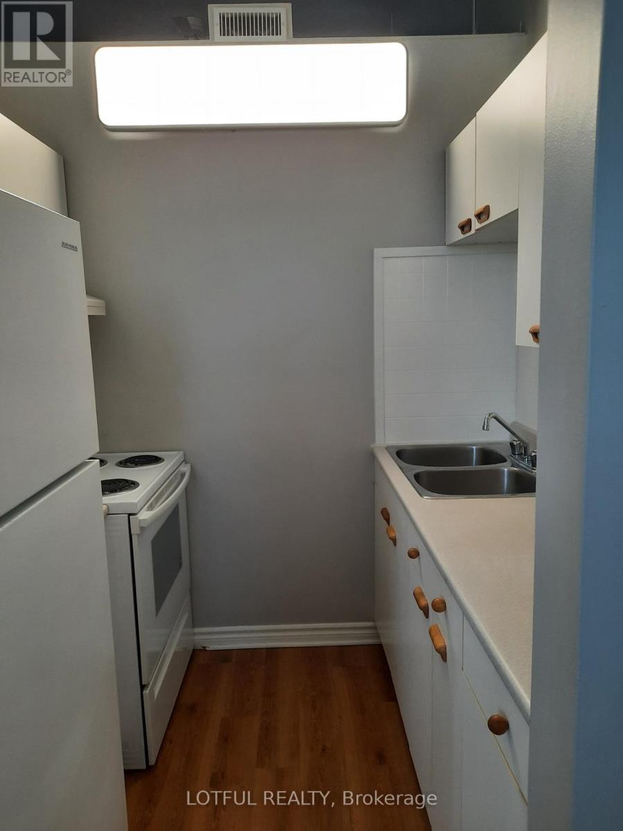 A small kitchen with a white refrigerator and a white oven.