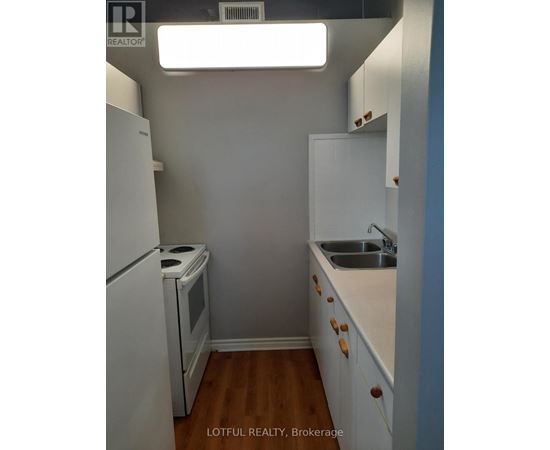 A small kitchen with a white refrigerator and a white oven.