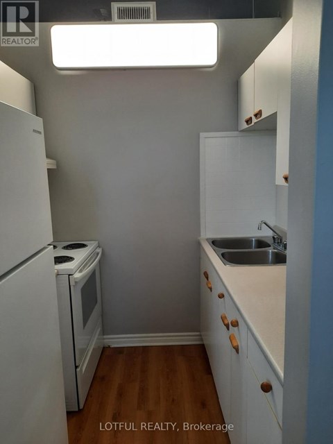 A small kitchen with a white refrigerator and a white oven.