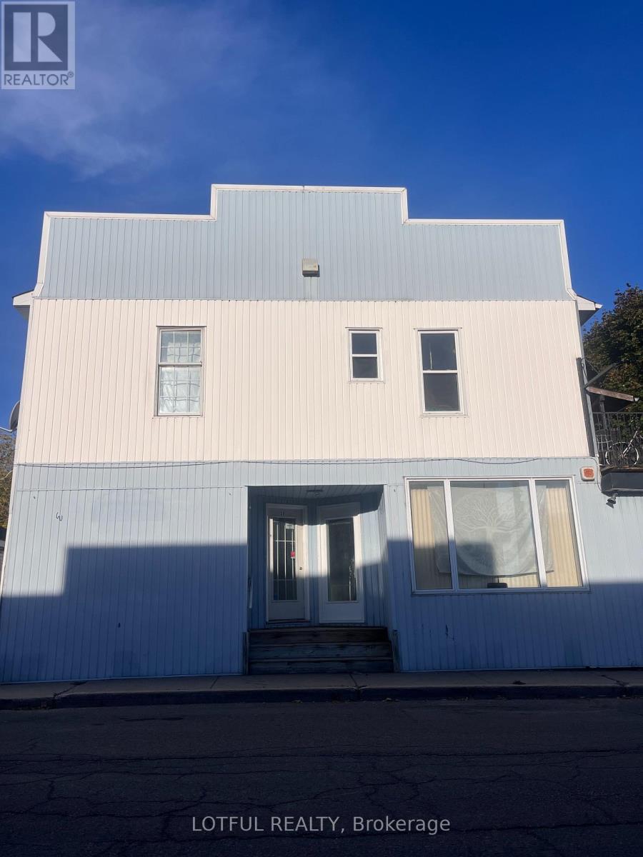 A white building with a blue roof and a sign that says Lotful Realty, Brokerage.
