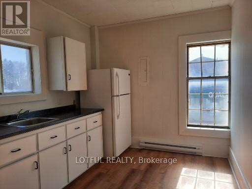 A kitchen with white cabinets and a window.