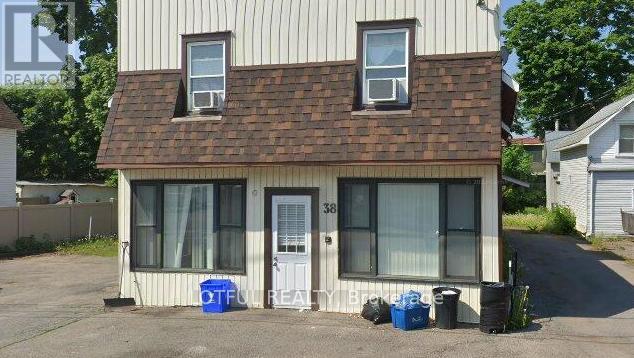 A house numbered 38 with a blue container in front.