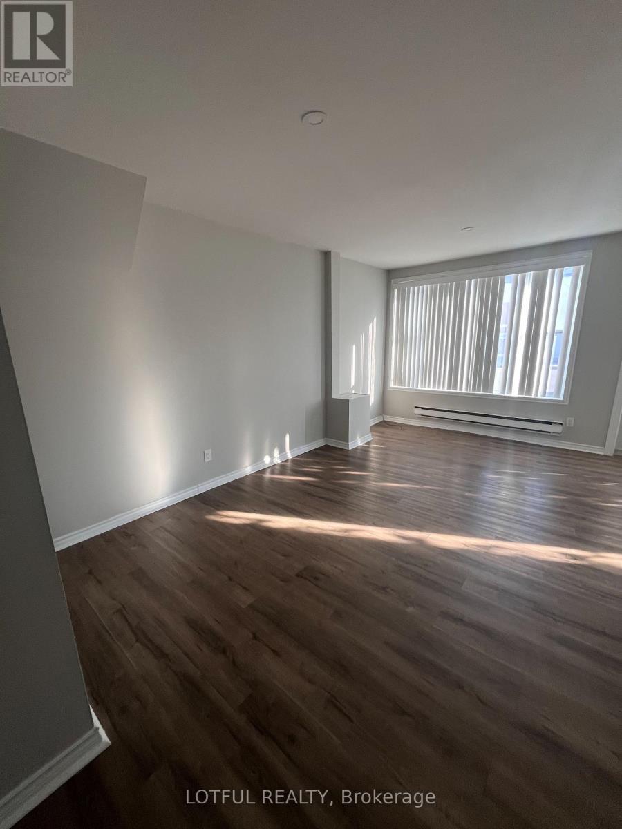 A room with wooden flooring and a window with blinds.