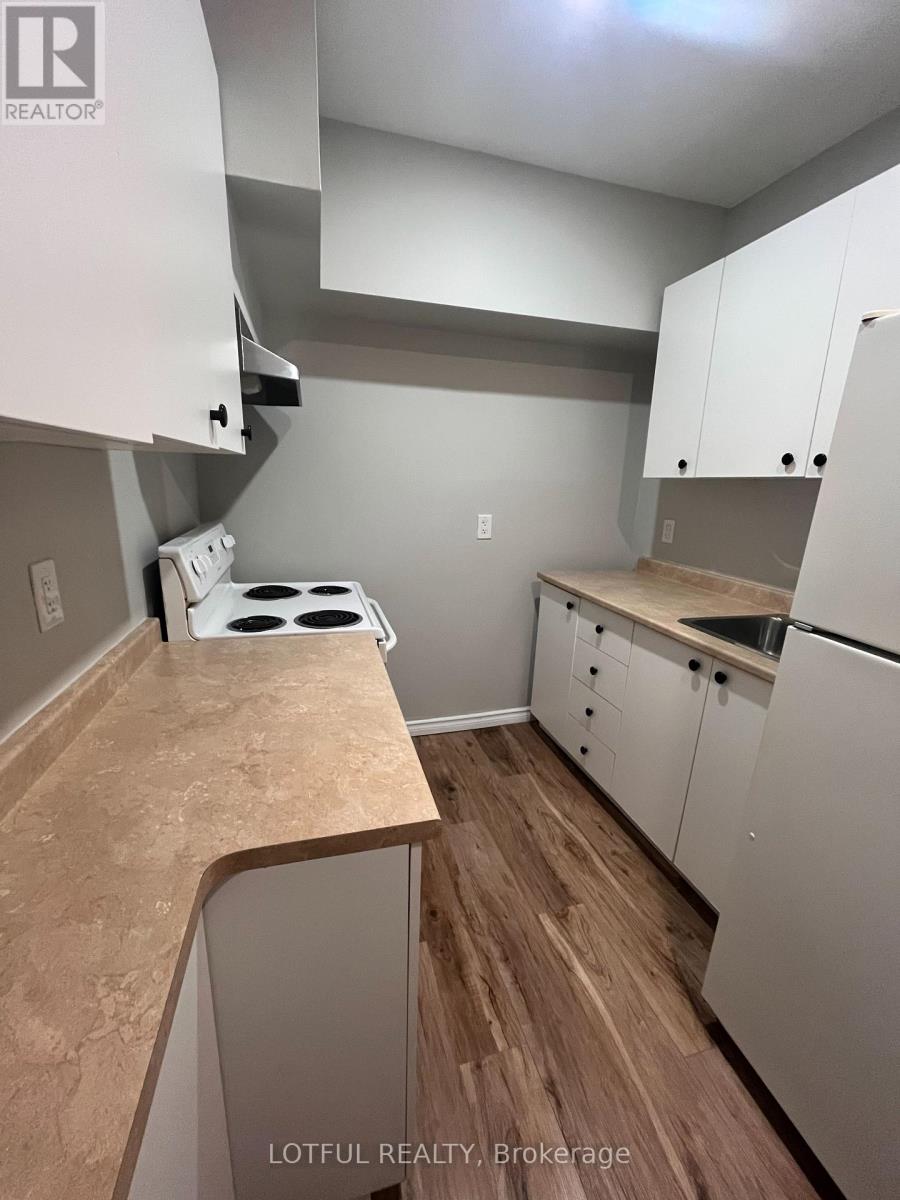 A kitchen with white cabinets and a wooden floor.