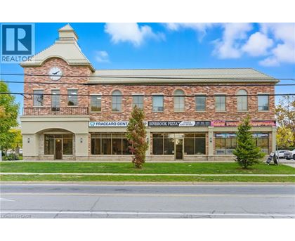 A building with a clock tower and a realtor logo.