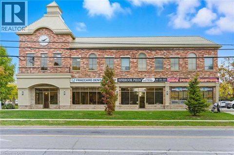 A building with a clock tower and a realtor logo.
