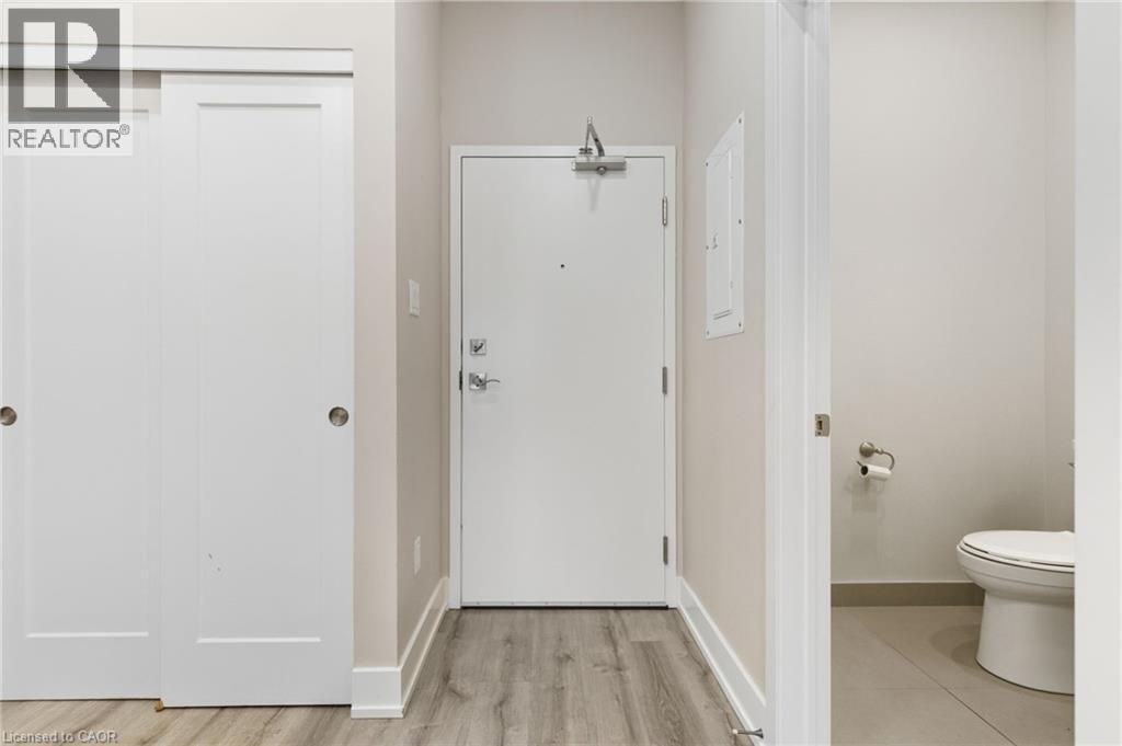 A white door in a room with a toilet in the background.