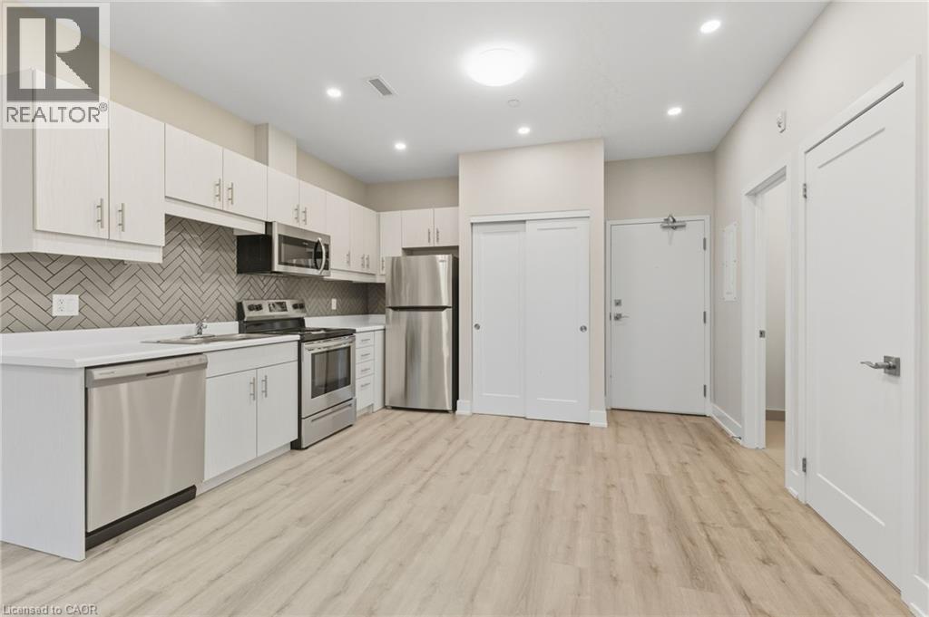 A kitchen with white cabinets and a wooden floor.