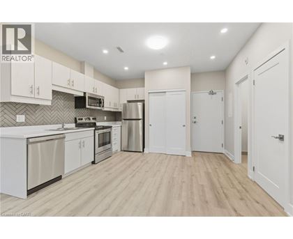 A kitchen with white cabinets and a wooden floor.