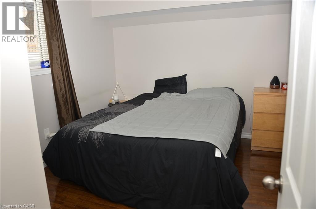 A bedroom with a bed, nightstand, and a lamp.