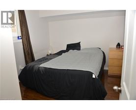 A bedroom with a bed, nightstand, and a lamp.