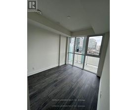 A room with a view of a cityscape through large windows.