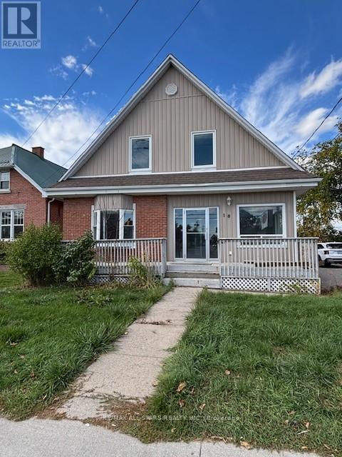 A house with a porch and a green lawn in front.