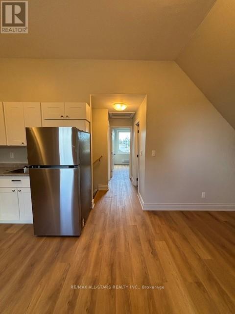 A kitchen with a refrigerator and cabinets.