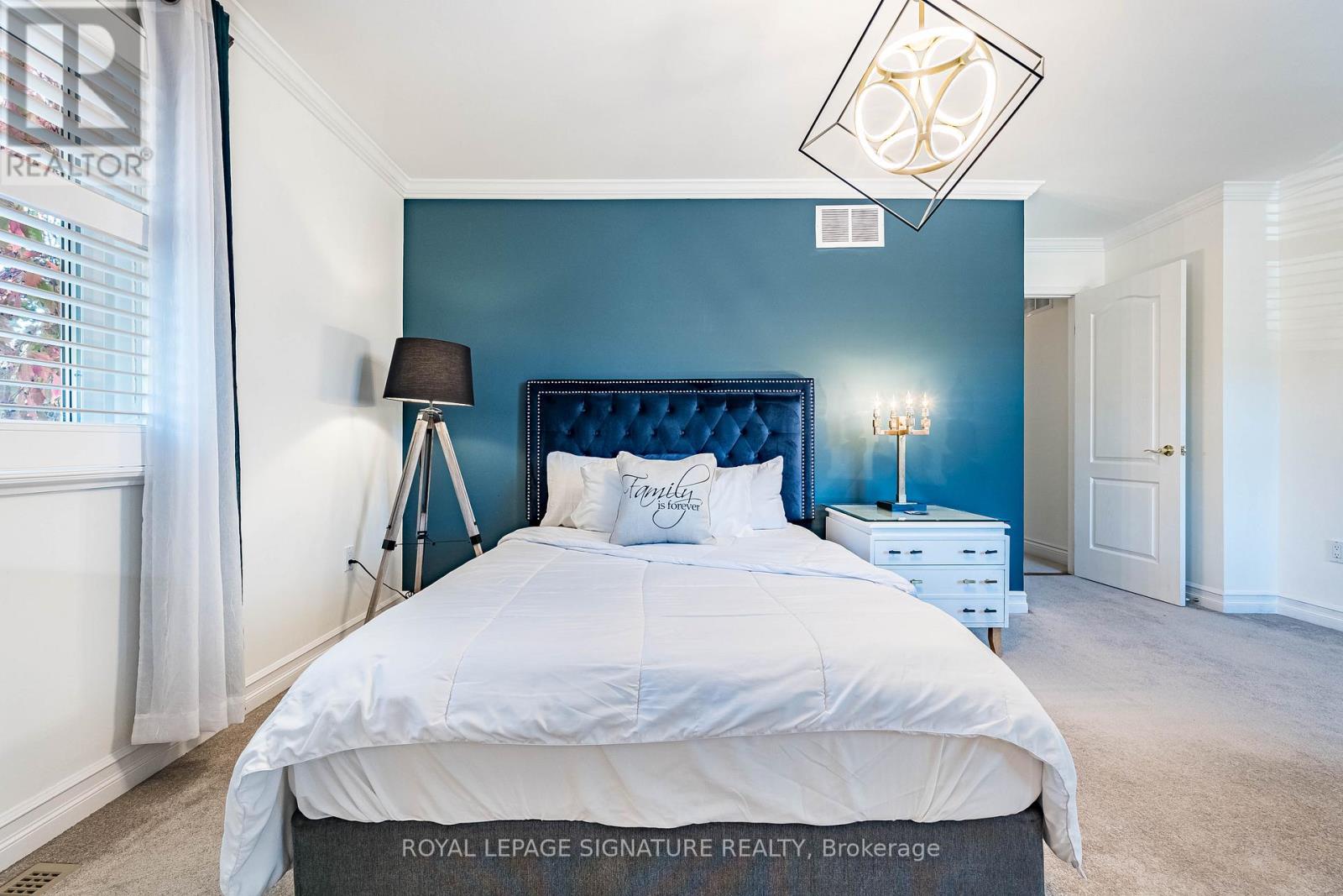 A bedroom with a white bed and a blue headboard.