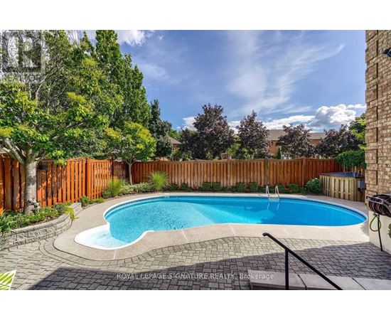 A small kidney-shaped pool surrounded by a brick border.