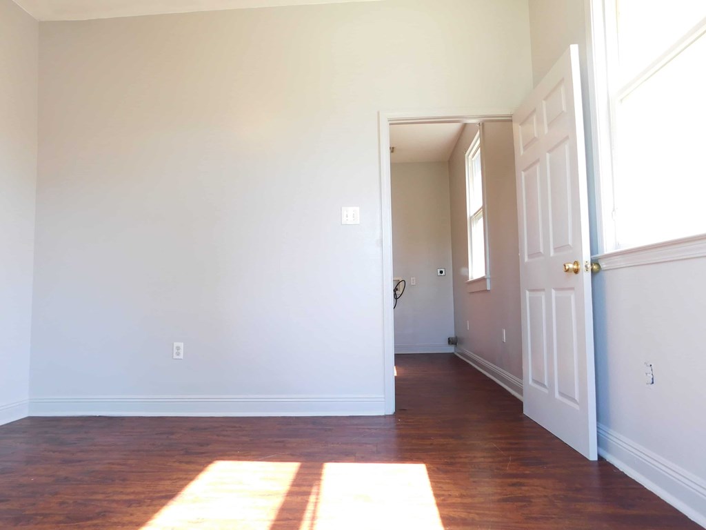 A room with white walls and a wooden floor.