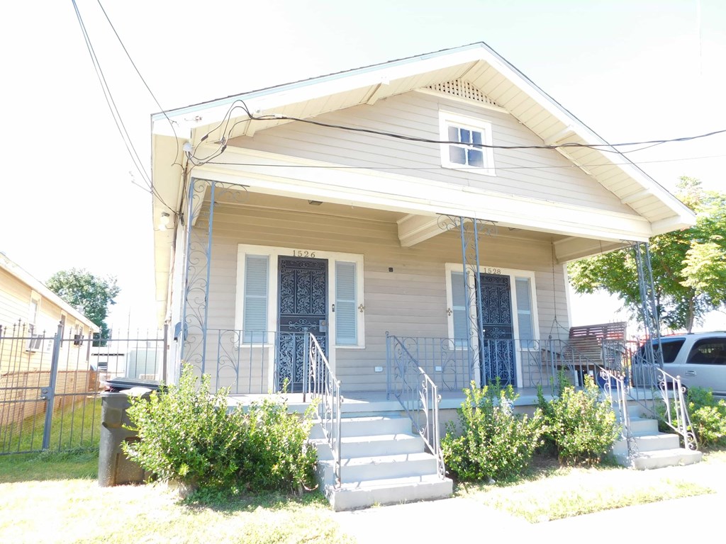 A house with a grey siding and a white door.
