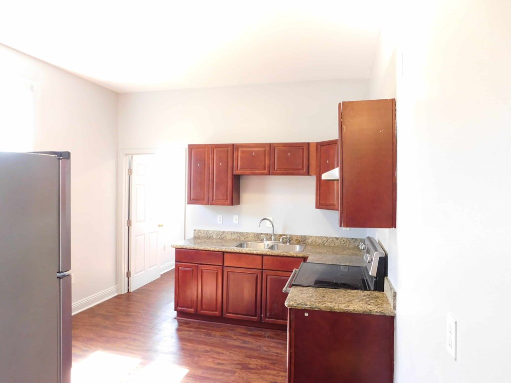 A kitchen with wooden cabinets and a granite countertop.
