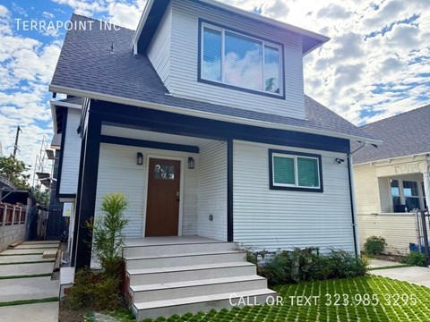A house with a brown door and a sign that says "Terrapoint Inc." on the roof.