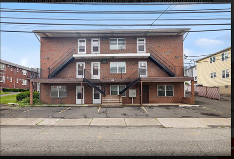 A red brick building with a parking lot in front.