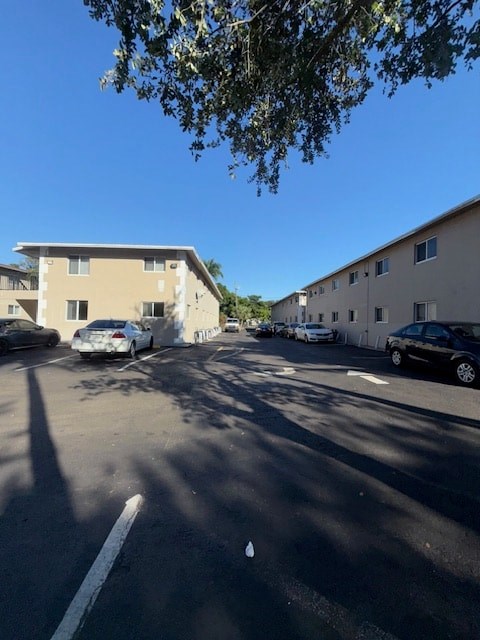 A parking lot with cars and apartment buildings in the background.