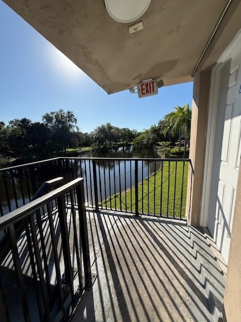 A balcony with a black railing and a white door.