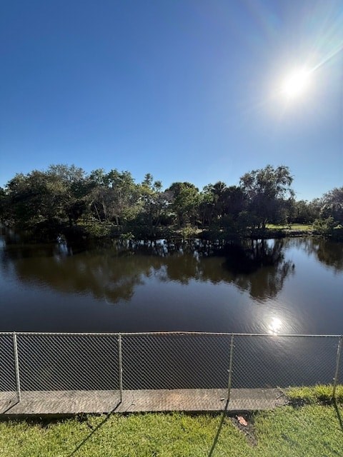 A sunny day at the lake with a fence in the foreground.