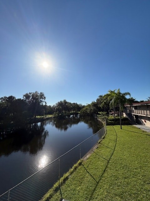 A serene landscape with a river, a clear blue sky, and a building in the distance.