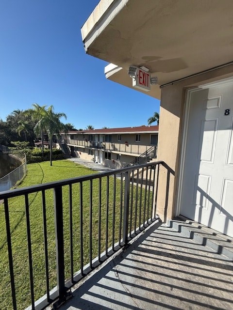 A balcony with a black railing and a white door with the number 8 on it.