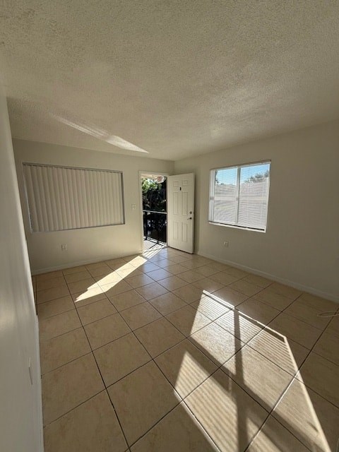 A room with a tiled floor and a door leading to a balcony.