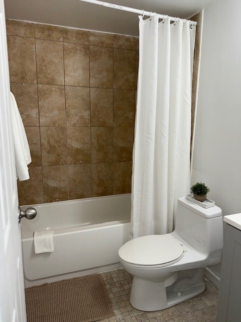 A white toilet sits next to a bathtub in a bathroom.