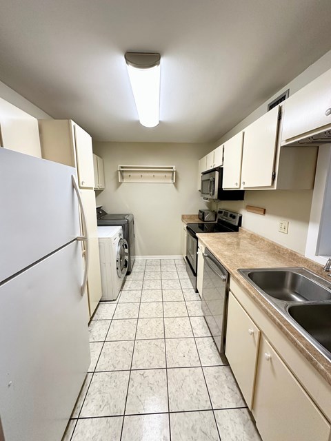 A kitchen with white appliances and white cabinets.