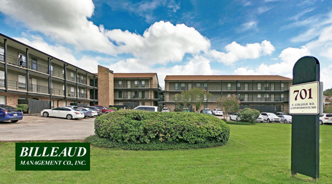 A green sign with the number 701 on it stands in front of a parking lot.