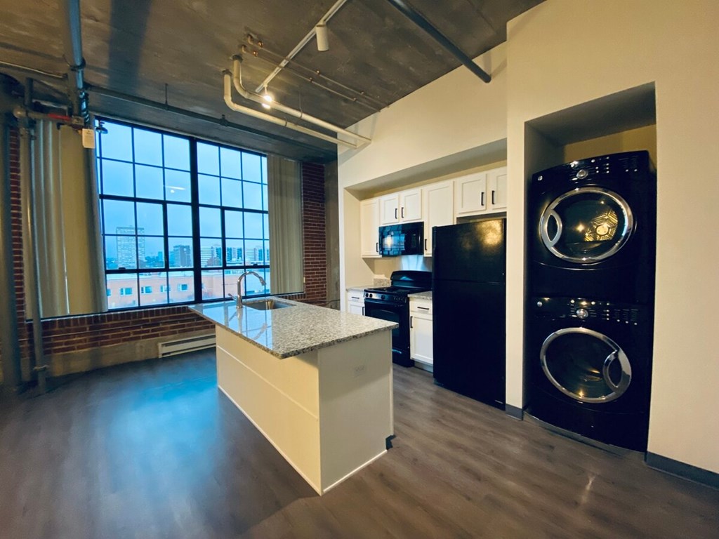 A modern kitchen with a large island and stainless steel appliances.