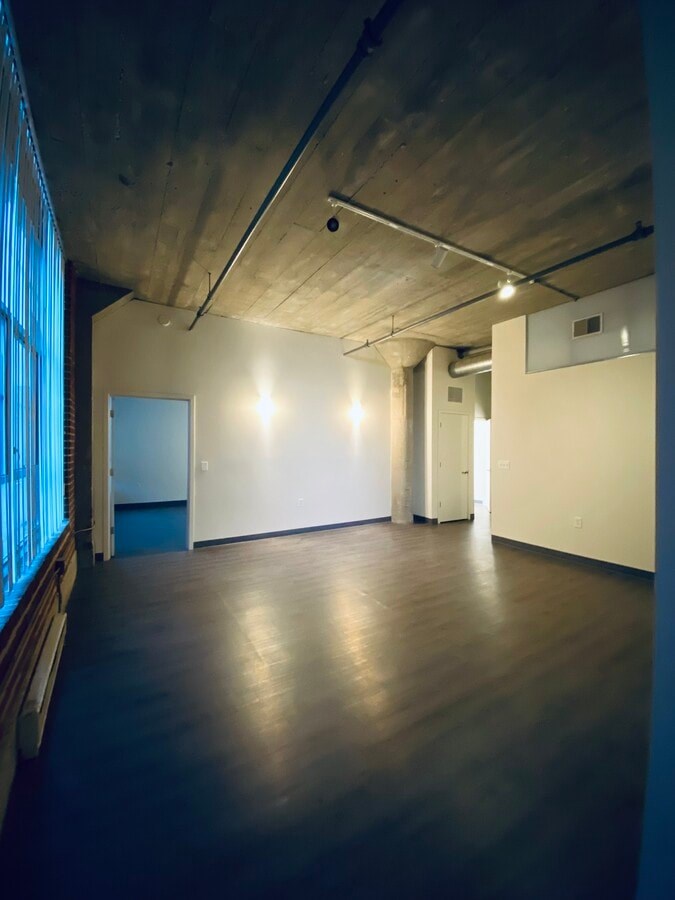 A large empty room with wooden floors and white walls.