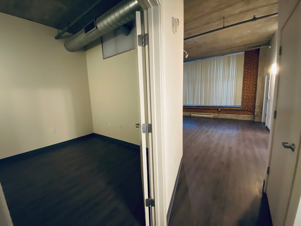 A room with a door and a window with blinds.