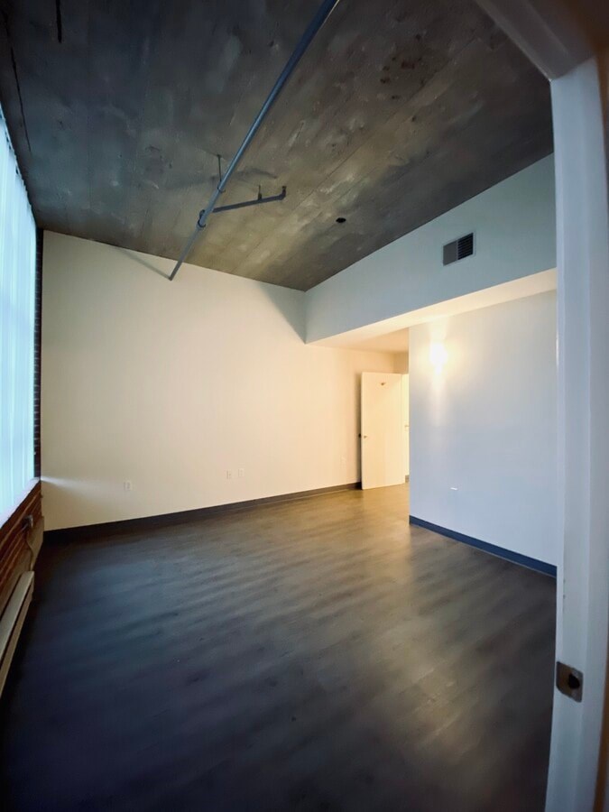 A room with a wooden floor and a white wall.