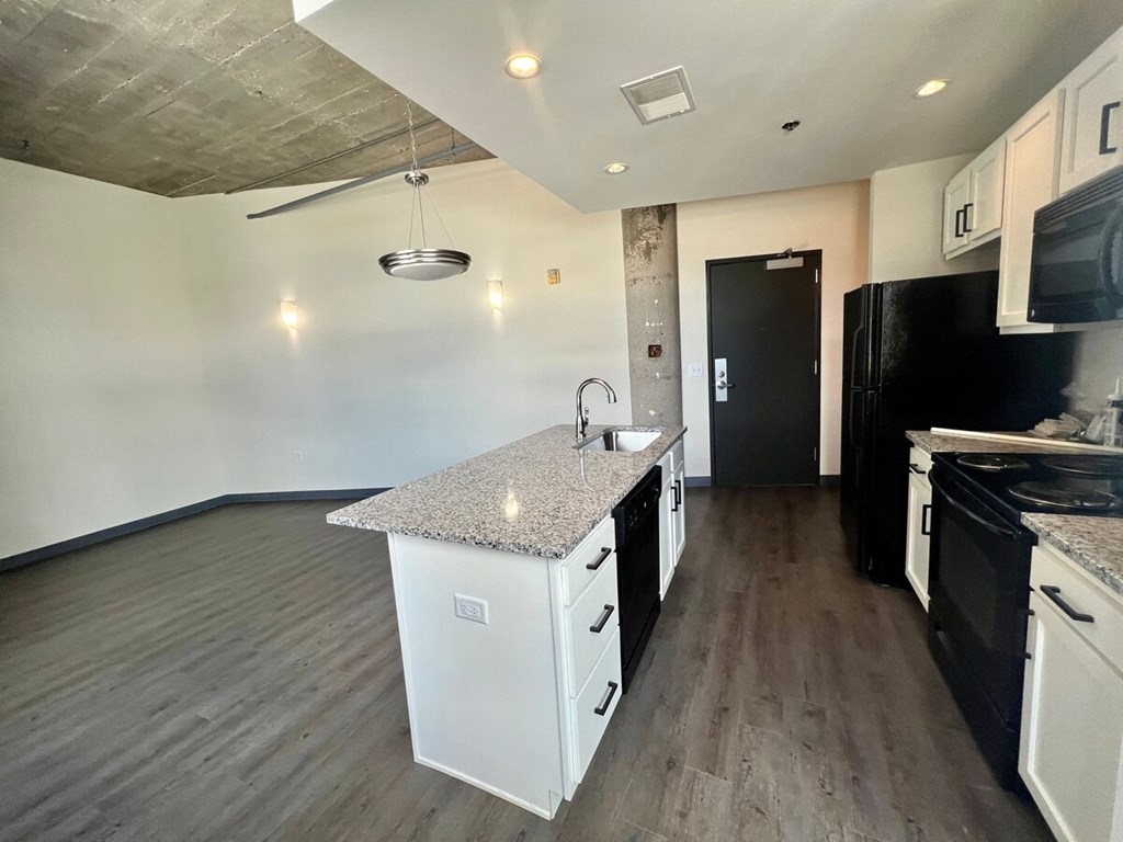 A kitchen with black appliances and white cabinets.