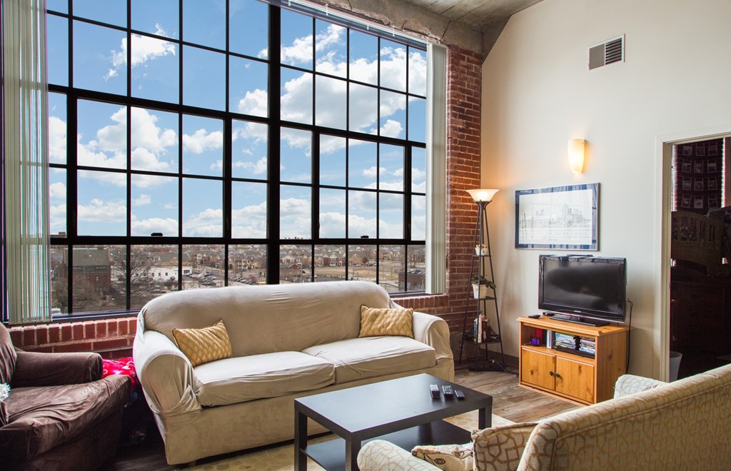 A living room with a large window overlooking the city.