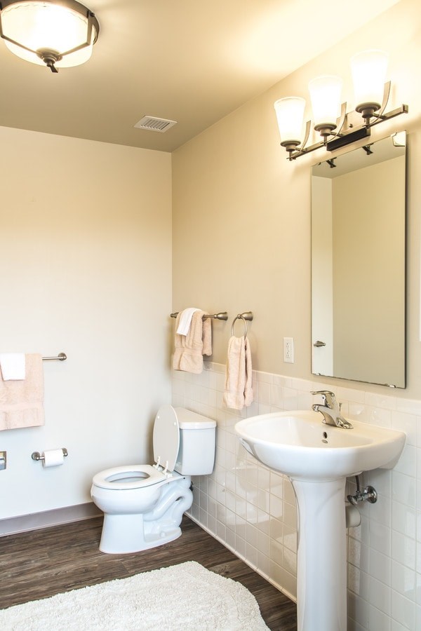 A white toilet and sink in a bathroom.